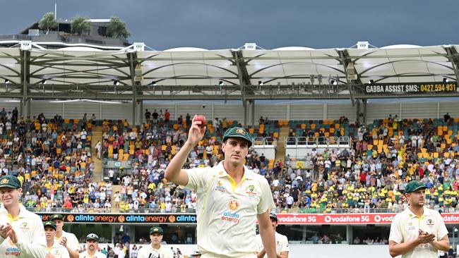 Pat Cummins walks off the Gabba with historic figures. Picture: Bradley Kanaris/Getty