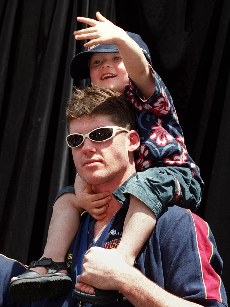 Bailey Lambert on the shoulders of Lions legend Jonathan Brown after the 2002 Grand Final. Picture: David Kapernick