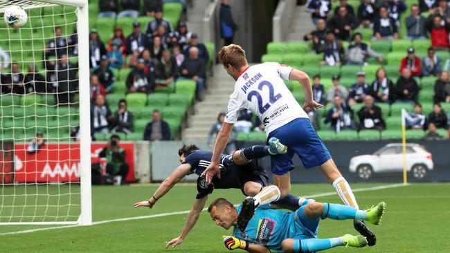 Melbourne Victory’s Robbie Kruse scores despite colliding with Jets keeper Glenn Moss and defender Lachlan Jackson. Picture: AAP