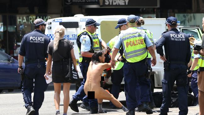 Police arrest a naked protester at the end of the Invasion Day march from Hyde Park to Victoria Park in Sydney. Picture: Richard Milnes/Shutterstock