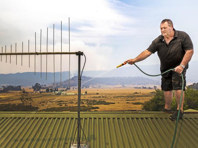 Fingal resident Tony Verren prepares for the approaching bushfire. Picture: CHRIS KIDD