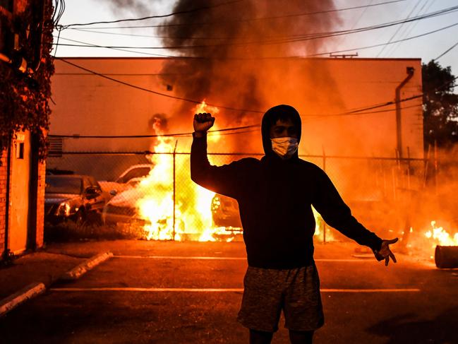 A protester gestures as cars burn behind him during a demonstration in Minneapolis, Minnesota. Picture: AFP