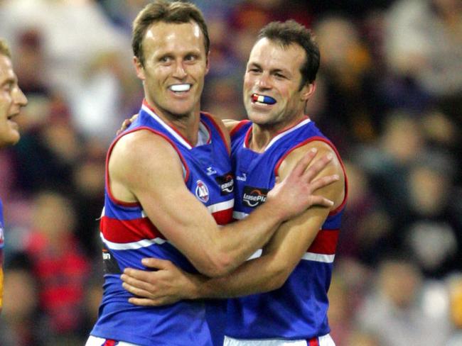 17 Jun 2006 : Bulldogs' Chris Grant and Brad Johnson celebrate a /goal as Lions' Michael Voss walks past dejected : Bris Lions vs Western Bulldogs at the Gabba : PicDarren/England - sport AFL f/l