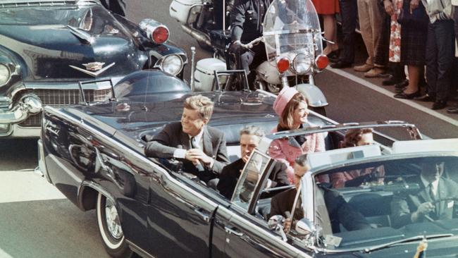 President John F Kennedy and his wife Jackie smile at the crowds lining their motorcade route in Dallas, Texas on November 22, 1963. Minutes later the President was assassinated as his car passed through Dealey Plaza.