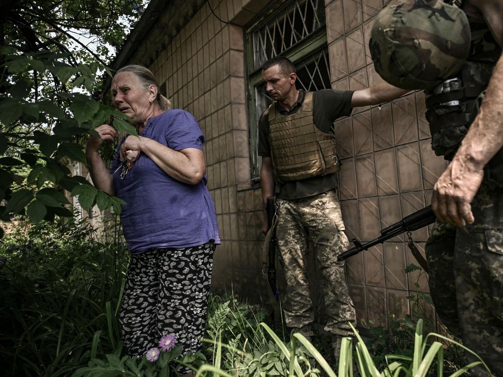 An elderly woman reacts as Ukrainian servicemen help her to take cover during artillery fire from Russian troops in the city of Lysychansk. Picture: AFP