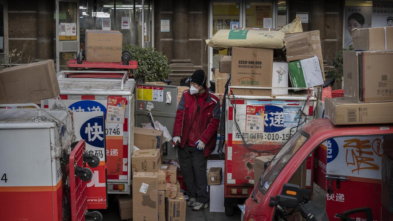 A delivery driver stands among packages in the street that are part of a backlog due to Covid-19 outbreaks outside a depot on December 21, 2022 in Beijing, China. Picture: Kevin Frayer/Getty Images