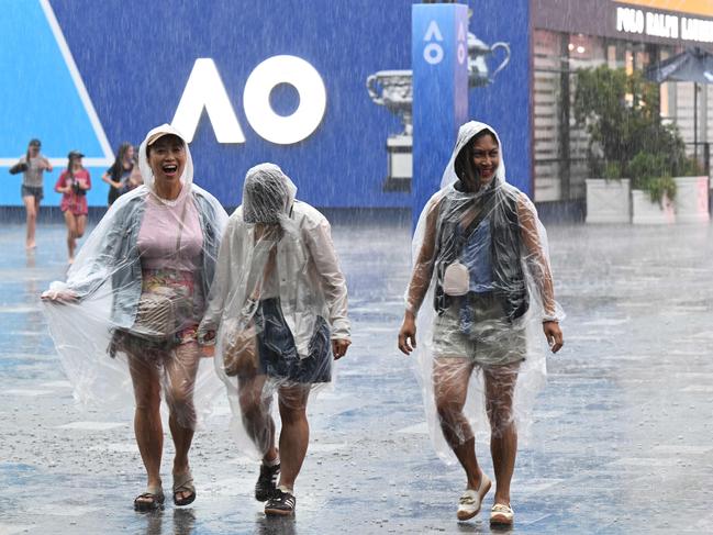 Tennis fans were forced to run for cover when the rain hit. Picture: AFP