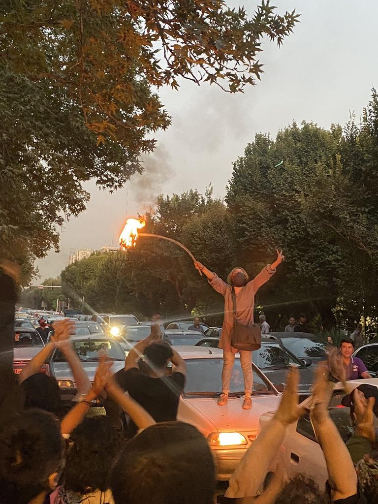 A woman sets a headscarf on fire in Tehran in protest over the death of Mahsa Amini. Picture: Twitter/Shayan86.