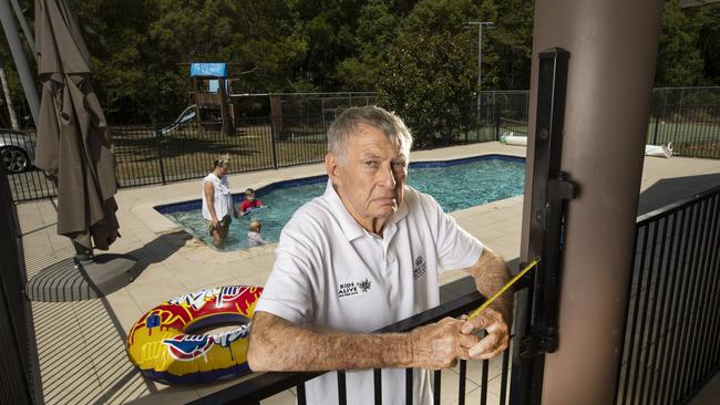 Former Olympic swimming coach Laurie Lawrence measures a pool fence. Picture: Nigel Hallett