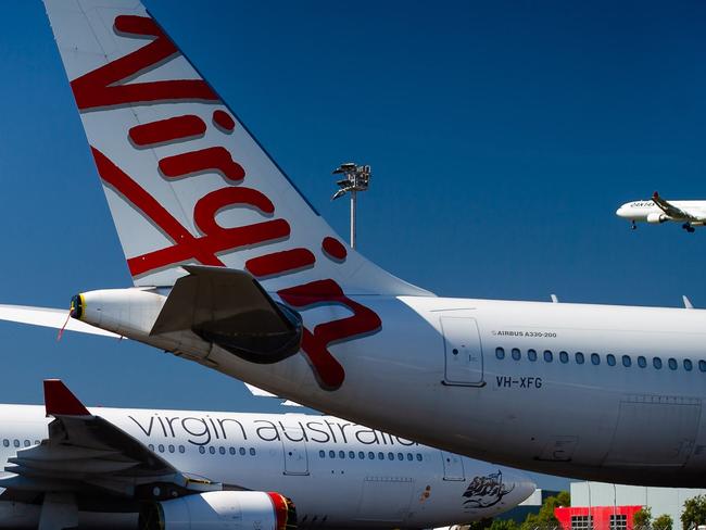 Virgin Australia aircraft are seen parked on the tarmac at Brisbane International airport on April 21, 2020. - Cash-strapped Virgin Australia collapsed on April 21, making it the largest carrier yet to buckle under the strain of the coronavirus pandemic, which has ravaged the global airline industry. (Photo by Patrick HAMILTON / AFP)