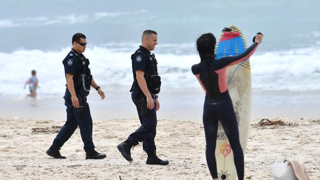 Police are seen patrolling the beach at Burleigh Heads. (AAP Image/Darren England)