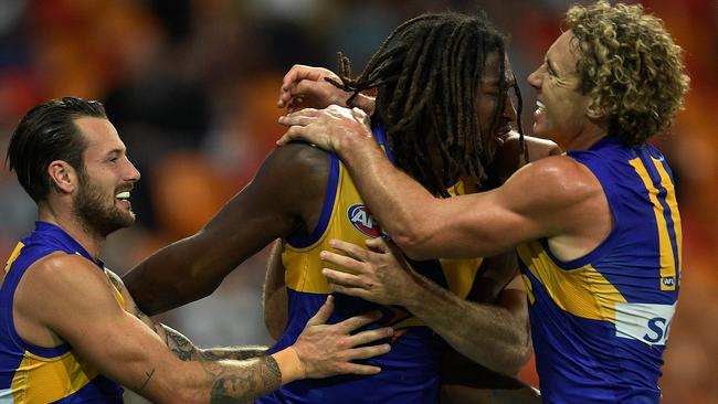 Nic Naitanui is mobbed by teammates Chris Masten and Matt Priddis after his match-winning goal. Picture: Getty Images