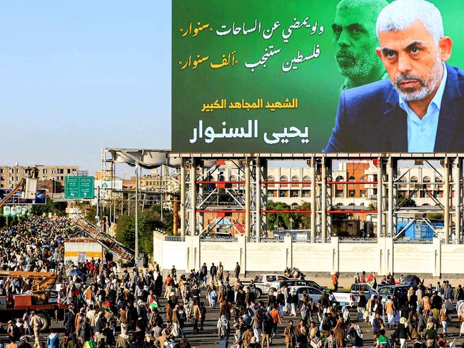 A billboard depicting Hamas' slain leader Yahya Sinwar with the Arabic slogan "if Sinwar departs from the battlefields, Palestine will birth a thousand Sinwars", during a rally in Yemen's Huthi-controlled capital Sanaa on October 18, 2024 in protest against Israel's attacks on Lebanon and the ongoing war between Israel and Hamas militants in the Gaza Strip. Israel announced on October 17 the killing of Sinwar, mastermind of the October 7 attack, calling his death a "heavy blow" to the Palestinian group it has been fighting for more than a year. (Photo by Mohammed HUWAIS / AFP)