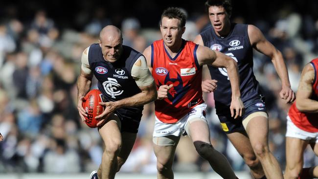 Brock McLean chases a sprinting Chris Judd in the years before joining Carlton.