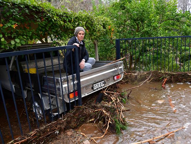 Sacha Tucker watches Waterfall Road turn into a river from her father’s ute last week. Picture Mark Brake