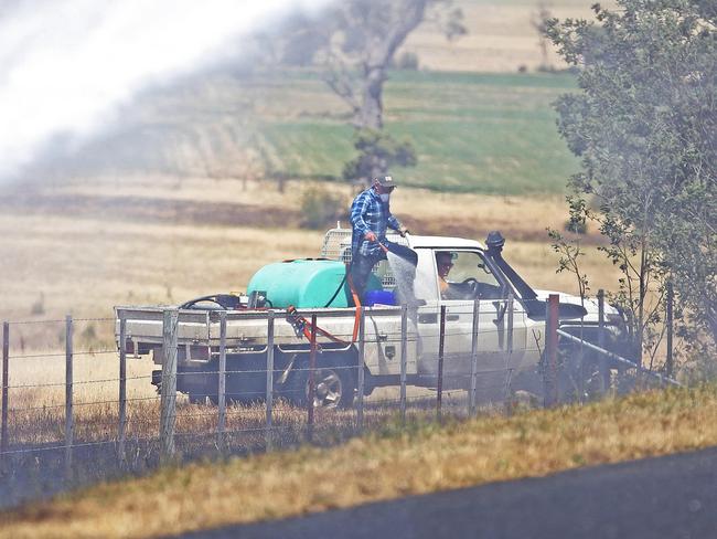 Locals look to contain a fire along Elderslie Rd, Elderslie. Picture: ZAK SIMMONDS