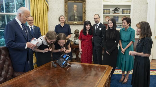 President Joe Biden (L), with prisoners relatives, watches as sisters Miriam (3rd L) and Bibi Butorin speak with their mother, released prisoner journalist Alsu Kurmasheva, in the Oval Office of the White House.