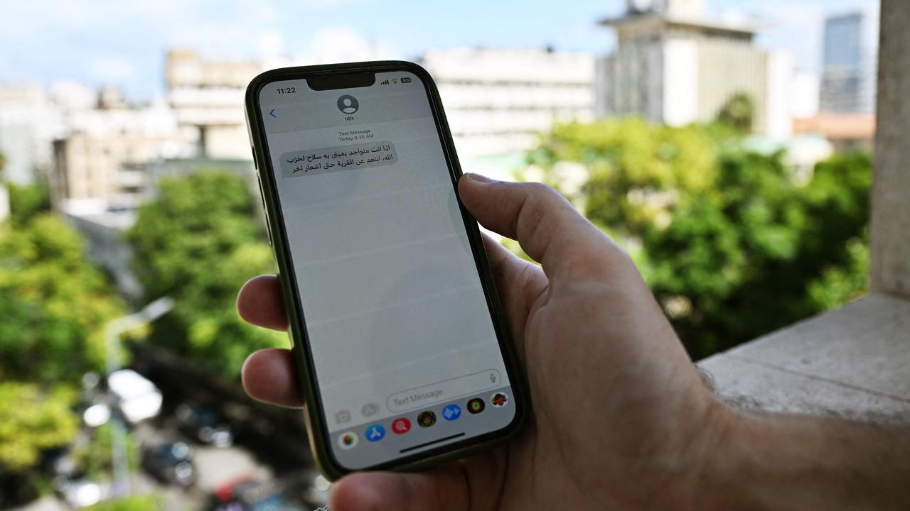 A Lebanese man checks a message received on his mobile phone in Beirut on September 23, 2024, calling people to evacuate the areas where Hezbollah hides its weapons. (Photo by JOSEPH EID / AFP)