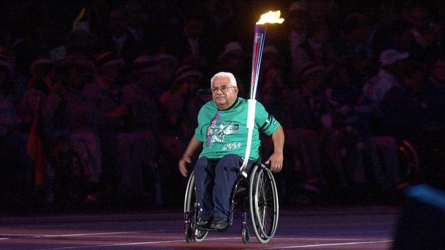 Kevin Coombs bears the torch into Stadium Australia at the Sydney 2000 Paralympic Games opening ceremony.