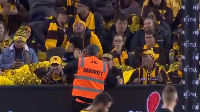 A security guard speaking to a member of the Hawthorn cheer squad. Picture: Channel 7