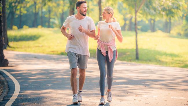 Portrait of Young couple running in the park at sunset. Concept sport and love. Warm tone.