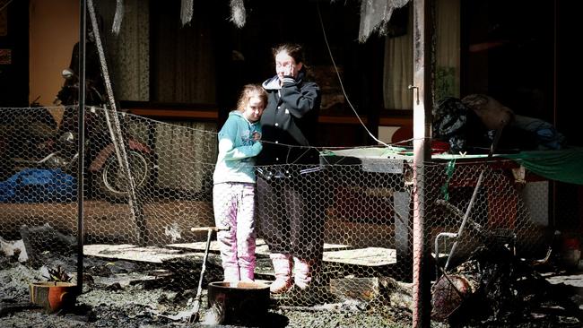 Lana Estrich and her daughter Isabella Quirk, 9, in what remains of ther home on Caves Road at Stanthorpe on Saturday.