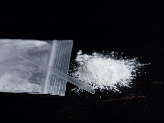 ketamine drugs and plastic straw on bag of white powder on black wood background.Drug epidemic concept.