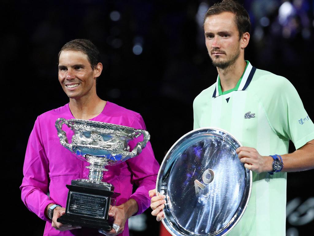 Spain's Rafael Nadal (L) poses with the winner's trophy next to Russia's Daniil Medvedev after the 2022 Australian Open final.