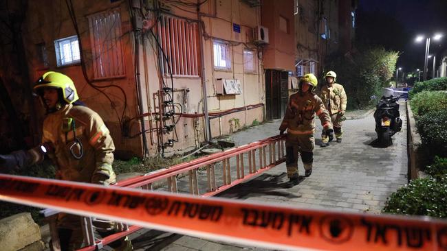 Israeli emergency responders transport a ladder at the site where a projectile fired from Yemen landed, in Tel Aviv. Picture: AFP