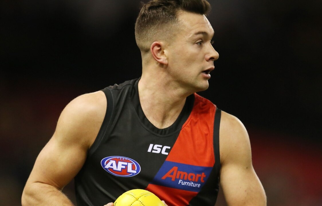 AFL postpones match after Essendon player tests positive for COVID-19