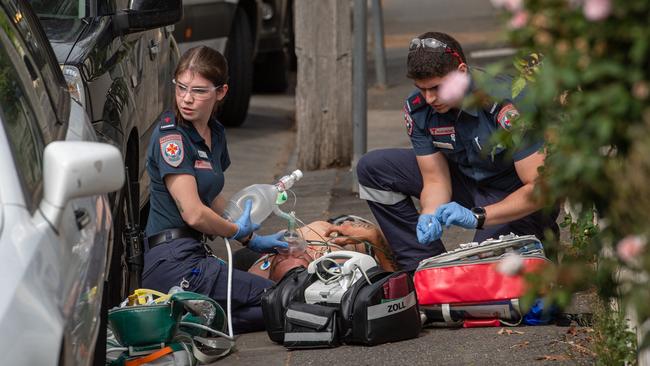 Paramedics treat a man near Richmond West Primary. Picture: Jason Edwards