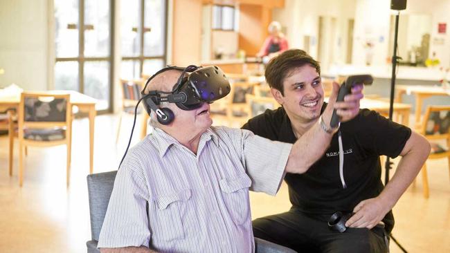 INTO THE BLUE: Bluecare resident Malcolm Hamilton, 74, trials a scuba diving scenario with Nomad VR CEO and founder Jarrah Cohen at the Blue Care Toowoomba Aged Care Facility. Picture: Nev Madsen