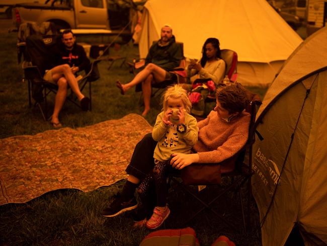 People sit and wait at the showgrounds in the southern New South Wales town of Bega where they are camping after being evacuated from nearby sites affected by bushfires on December 31, 2019. - Thousands of holidaymakers and locals were forced to flee to beaches in fire-ravaged southeast Australia on December 31, as blazes ripped through popular tourist areas leaving no escape by land. Picture: Sean Davey/AFP