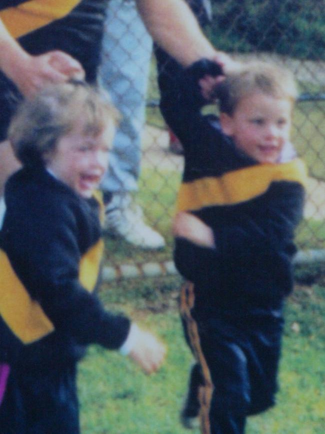 Travis Boak, right, running out onto the oval for his dad, Roger’s, 200th game for Torquay Tigers with his sister Sarah.