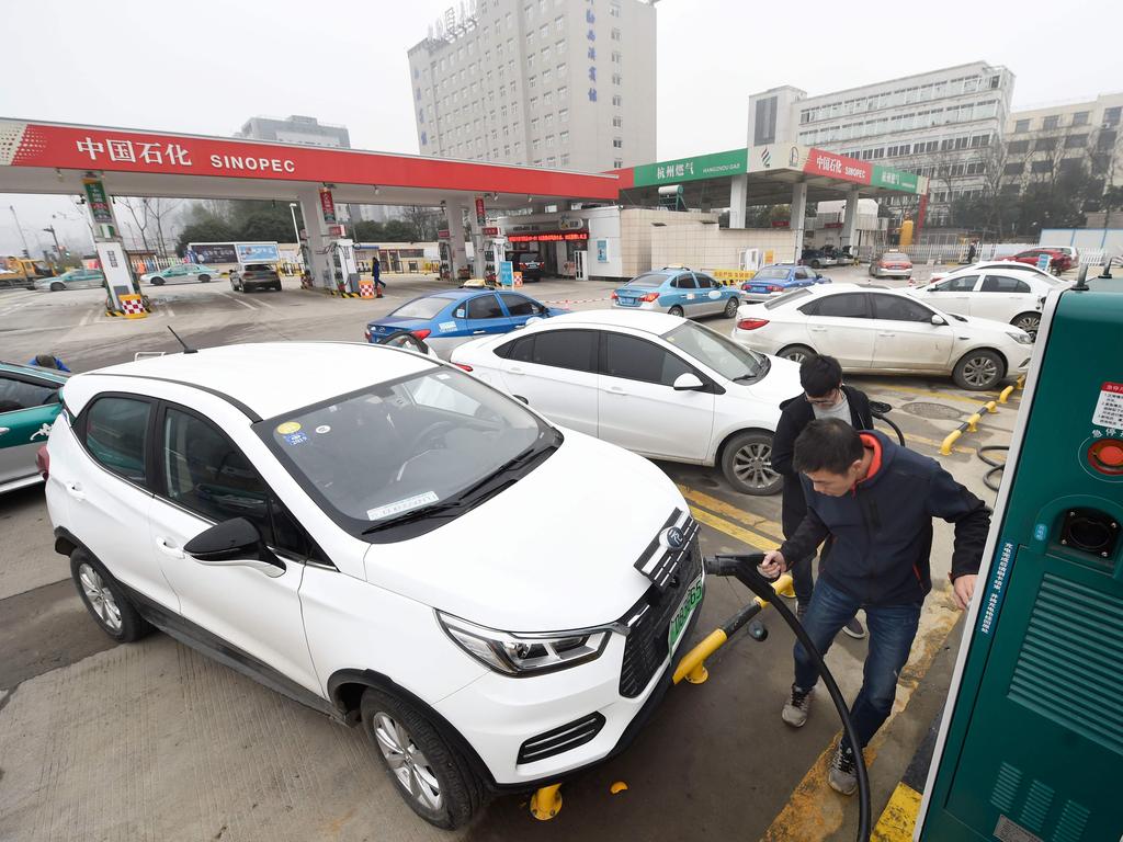 A man plugging in an electric vehicle in Hangzhou, in China's eastern Zhejiang province. Picture: STR/AFP