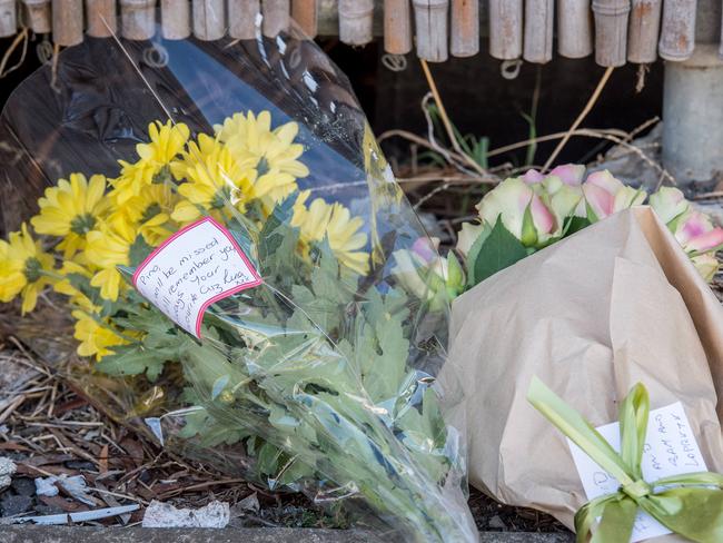 Mourners lay flowers at the murder site. Picture: Jake Nowakowski