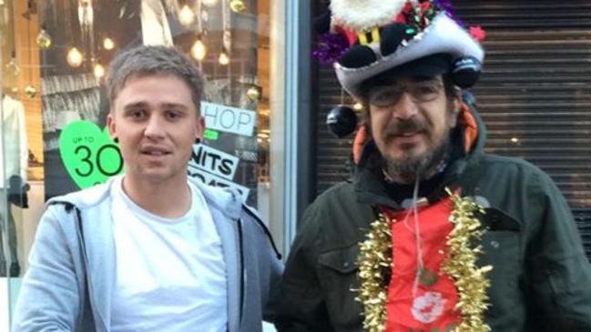 Lee Houghton shaking hands with Simon, a homeless British Big Issue vendor. Picture: UK Mirror