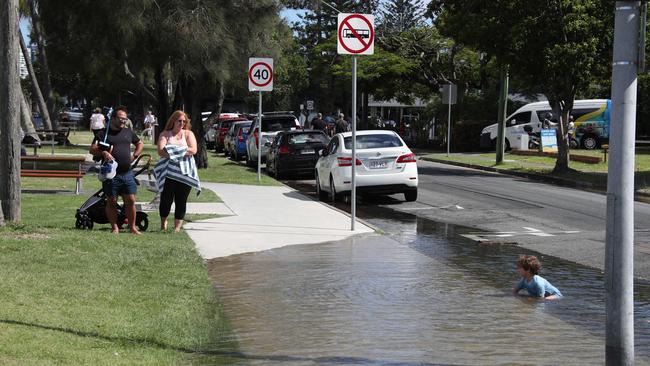 Flooding from the King tide at Budds Beach at Surfers Paradise was made worse by the approaching storm system. Locals Alberto Scuteri 4 enjoys the water, not so his parents. Picture Glenn Hampson