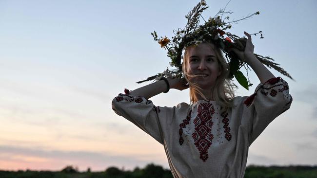 A woman wearing a wreath attends Kupala night celebrations after volunteering to clear debris from destroyed buildings in Chernihiv region. Picture: AFP