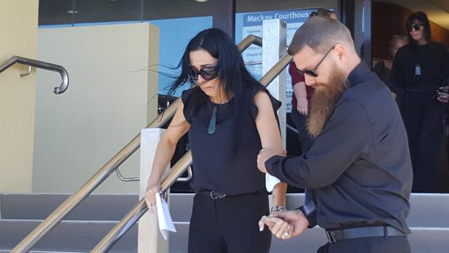 Shane Burke helps his devastated partner Kerri-Ann Goodwin down the stairs of Mackay Courthouse after the sentencing of their son Hemi Burke's killer, Matthew James Ireland.