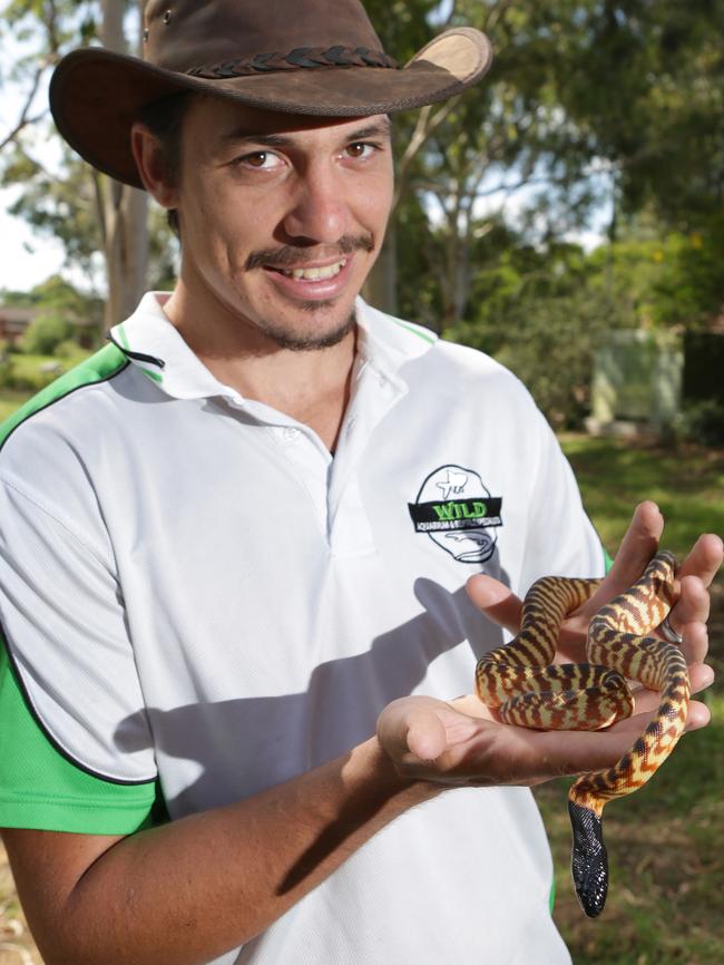 Kane at home with a pet python.