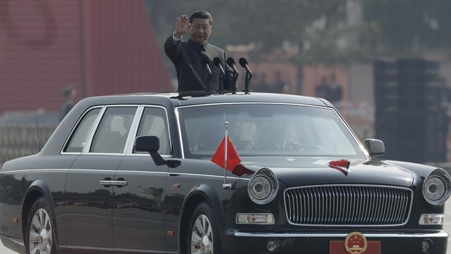 President Xi Jinping waves from an open-top limousine. Picture: AP