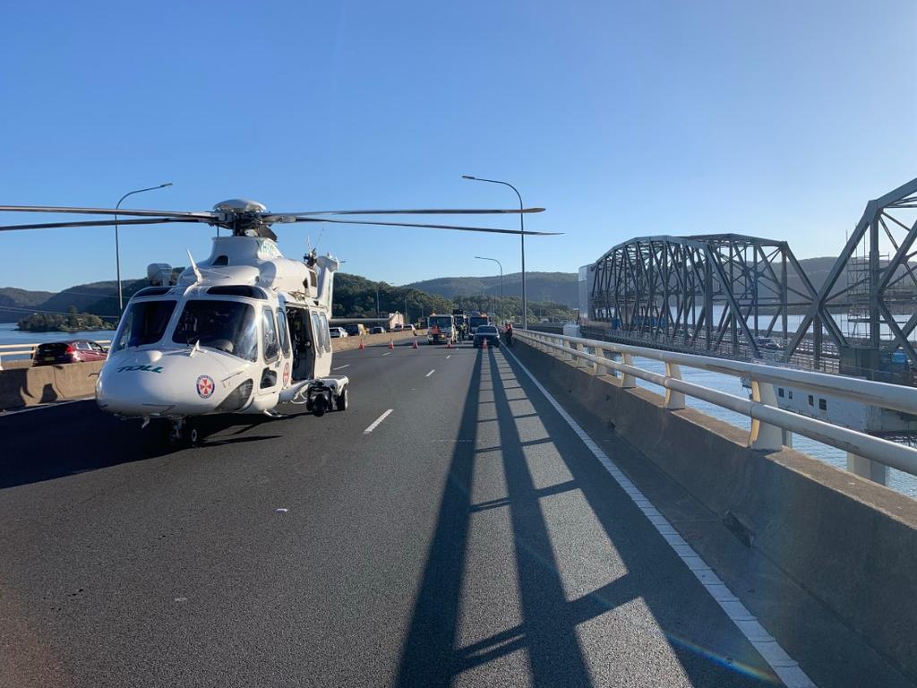 A Toll rescue helicopter has landed at the scene to assist transporting the injured driver. Picture: Live Traffic NSW
