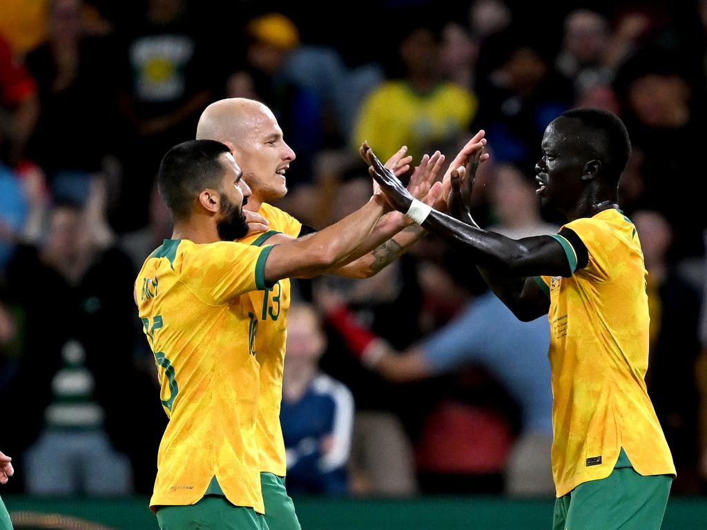 Awer Mabil (right) celebrates with teammates Aziz Behich (left) and Aaron Mooy after scoring against New Zealand. Picture: Bradley Kanaris/Getty Images