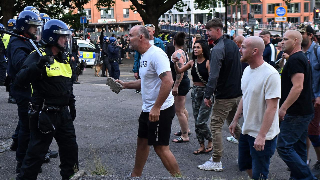 A protester holding a piece of concrete walks towards riot police as clashes erupt in Bristol on August 3 during the Enough is Enough demonstration held in reaction to the fatal stabbings in Southport. Picture: AFP