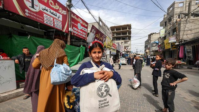 A girl carries a canvas bag filled with food aid as many desperately seek food. Picture: AFP