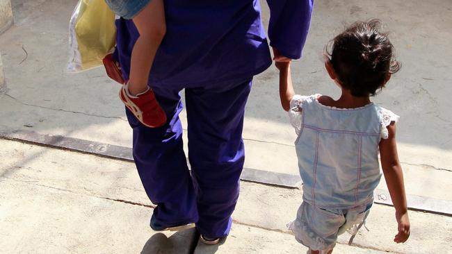 A female prisoner walks out of the prison with her children, at Prey Sar prison where Reaksmey was held in squalid conditions for eight months. Picture: EPA/MAK REMISSA.