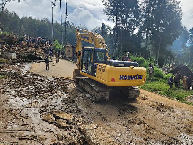 This handout photo from the International Organization for Migration shows an excavator driving towards the site of a landslide at Yambali Village in the region of Maip Mulitaka, in Papua New Guinea. Picture: AFP