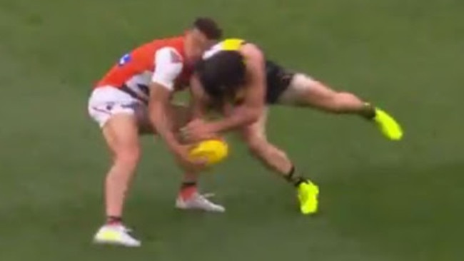 Trent Cotchin puts a big hit on Dylan Shiel.