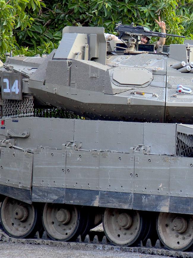 An Israeli soldier gives a peace sign from a tank stationed on the northern border with Lebanon.